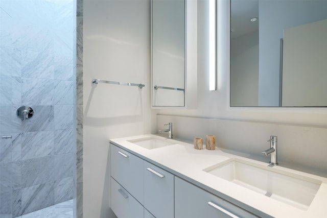 bathroom with a tile shower and vanity