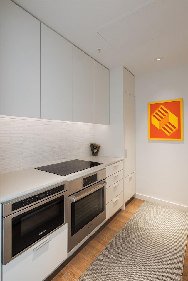 kitchen featuring white cabinetry and oven