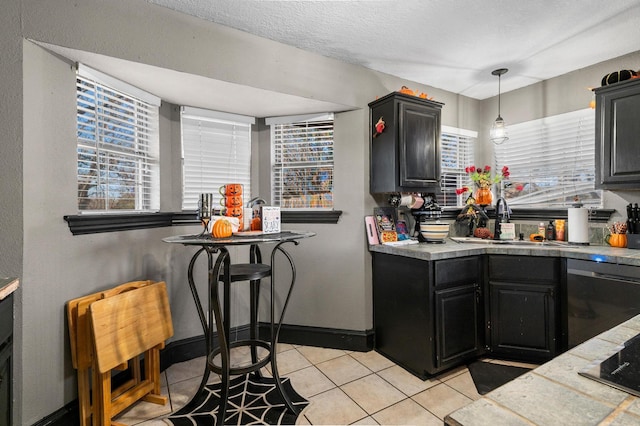 kitchen with dishwasher, light tile patterned floors, a wealth of natural light, and sink