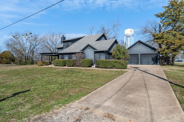 view of front of property featuring a garage, a front yard, and an outdoor structure