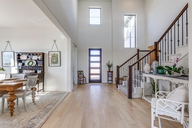 foyer entrance with light wood-type flooring and a high ceiling