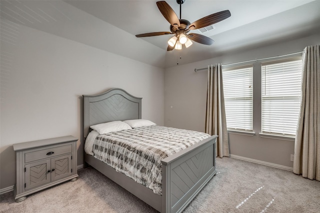 carpeted bedroom with vaulted ceiling, ceiling fan, and multiple windows