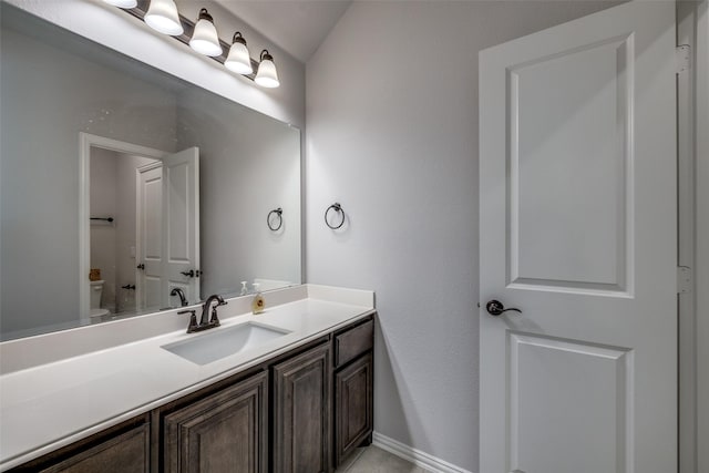 bathroom with toilet, tile patterned flooring, and vanity