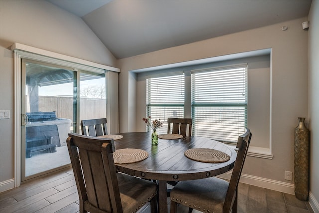 dining area with a healthy amount of sunlight, vaulted ceiling, and hardwood / wood-style floors