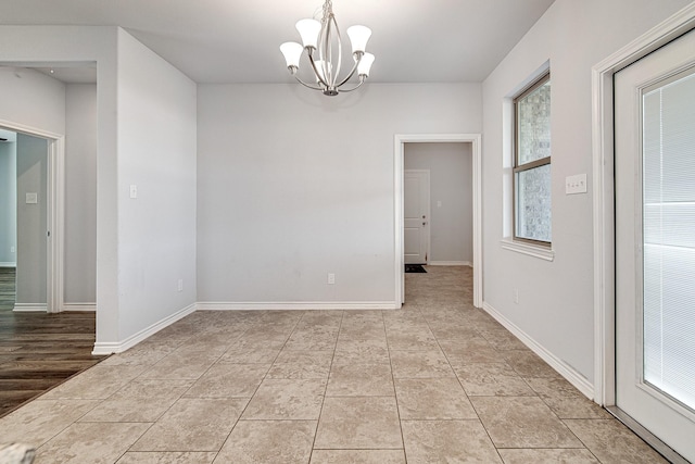 unfurnished room with a notable chandelier and light tile patterned floors