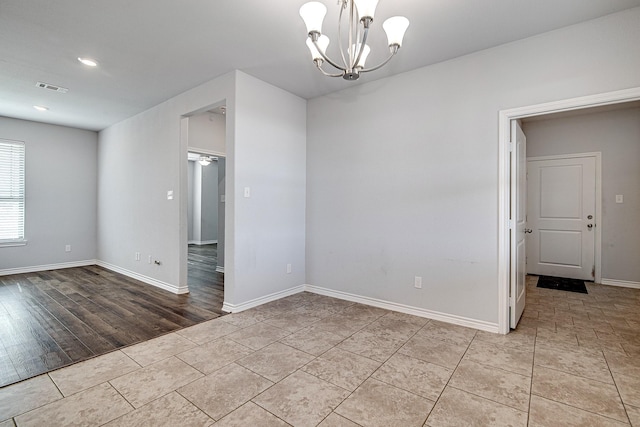 unfurnished room with light tile patterned flooring and an inviting chandelier