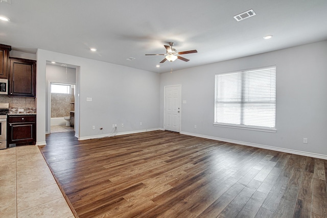 unfurnished living room featuring hardwood / wood-style flooring and ceiling fan