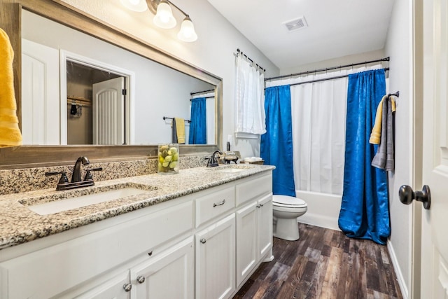 full bathroom with toilet, hardwood / wood-style flooring, shower / bath combo, and vanity