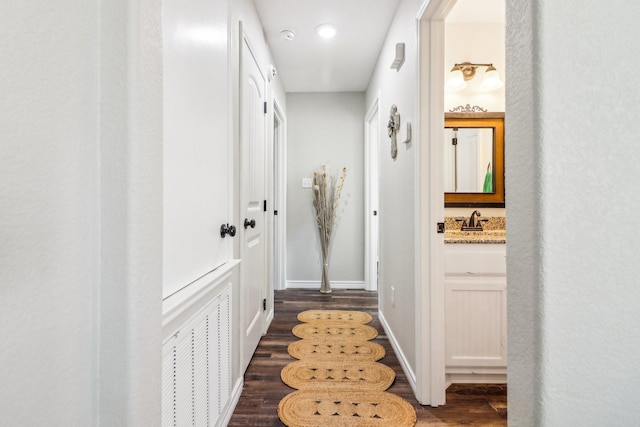 hallway featuring sink and dark hardwood / wood-style floors