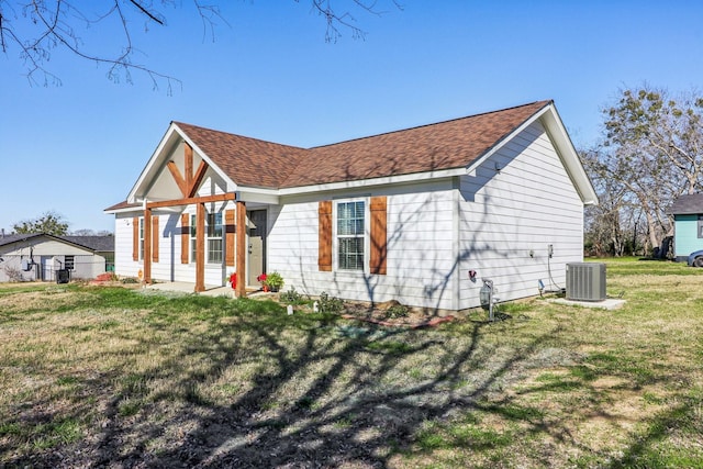 view of front facade with a front yard and central AC