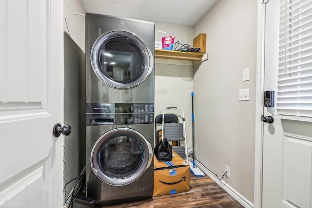 laundry room with dark wood-type flooring and stacked washing maching and dryer