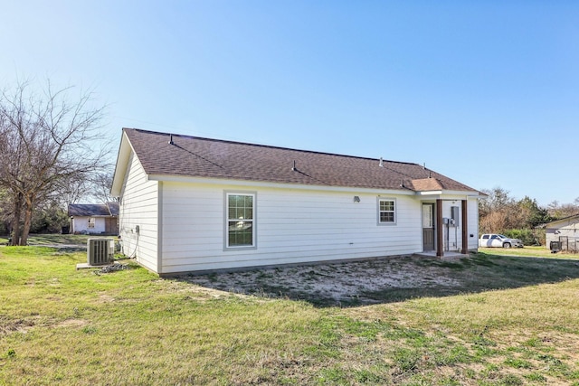 back of house with central AC and a lawn