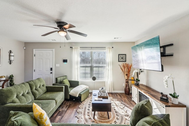 living room featuring ceiling fan and dark hardwood / wood-style flooring