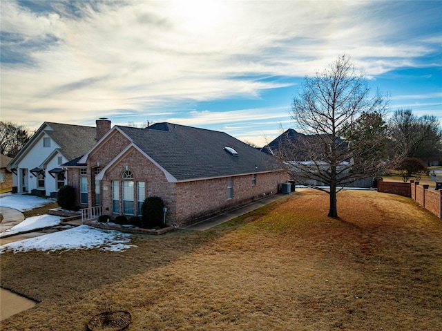 view of home's exterior with central AC and a lawn