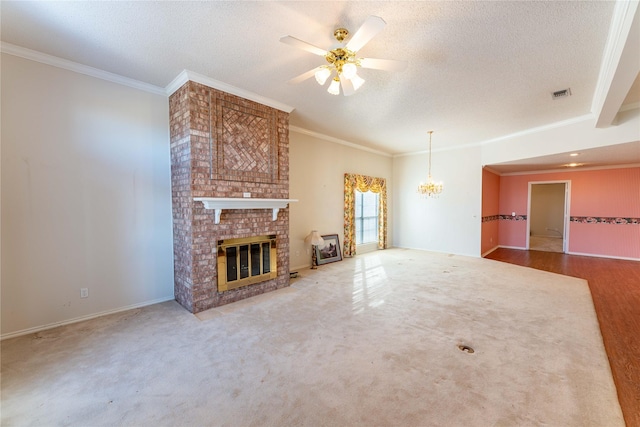 unfurnished living room with ceiling fan with notable chandelier, a brick fireplace, a textured ceiling, and crown molding