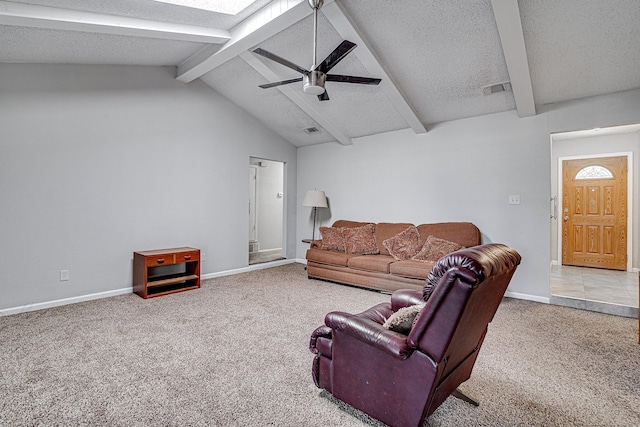 carpeted living room with ceiling fan, vaulted ceiling with beams, and a textured ceiling