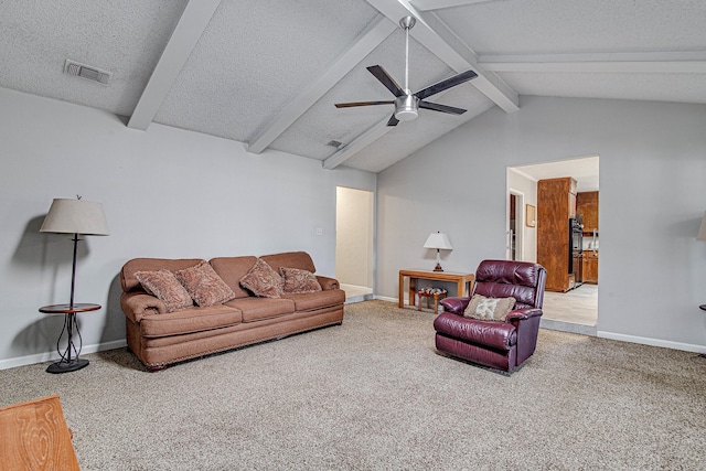 living room with ceiling fan, vaulted ceiling with beams, carpet floors, and a textured ceiling