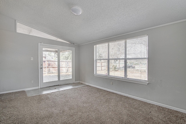 unfurnished room featuring a textured ceiling, light colored carpet, vaulted ceiling, and plenty of natural light