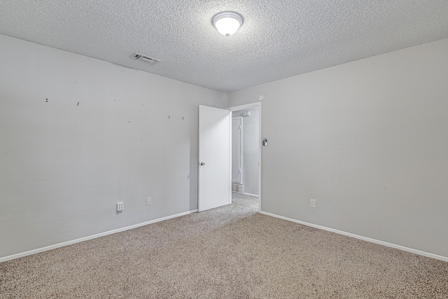 unfurnished room featuring a textured ceiling and carpet