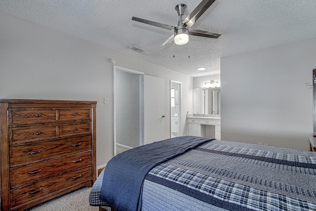 carpeted bedroom featuring ceiling fan, connected bathroom, and a textured ceiling