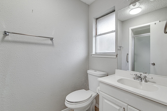 bathroom with toilet, vanity, a textured ceiling, and walk in shower