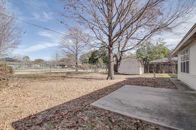 view of yard featuring a storage unit and a patio