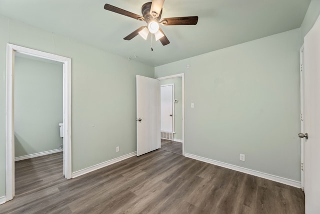 unfurnished bedroom featuring ceiling fan and dark hardwood / wood-style flooring