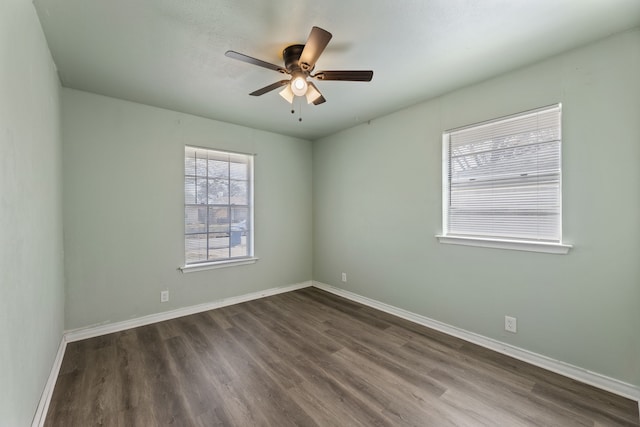 empty room featuring dark wood-type flooring and ceiling fan