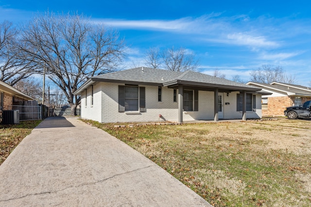 ranch-style home with central air condition unit and a front lawn