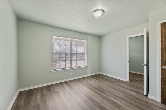 unfurnished room featuring a textured ceiling and hardwood / wood-style flooring