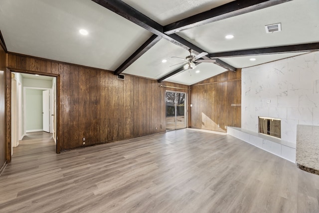 unfurnished living room with lofted ceiling with beams, a fireplace, ceiling fan, and light hardwood / wood-style floors