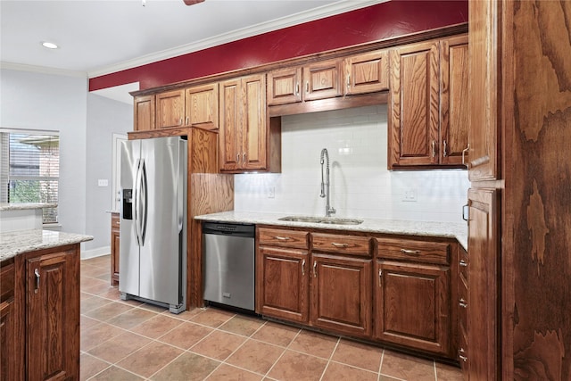 kitchen with light stone counters, decorative backsplash, appliances with stainless steel finishes, ornamental molding, and a sink