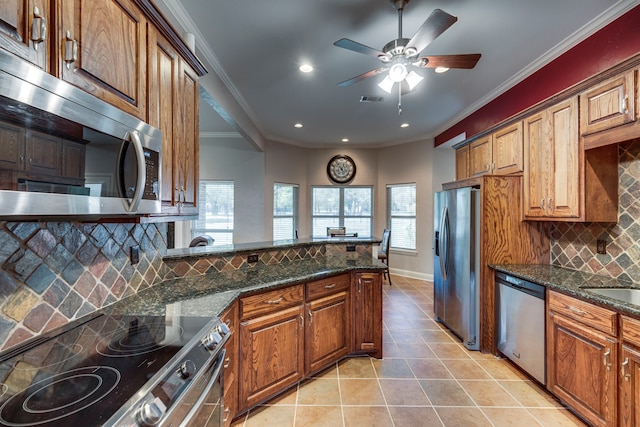 kitchen featuring dark stone countertops, crown molding, backsplash, appliances with stainless steel finishes, and ceiling fan