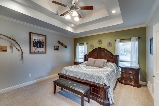 bedroom with ceiling fan, multiple windows, light carpet, and a tray ceiling