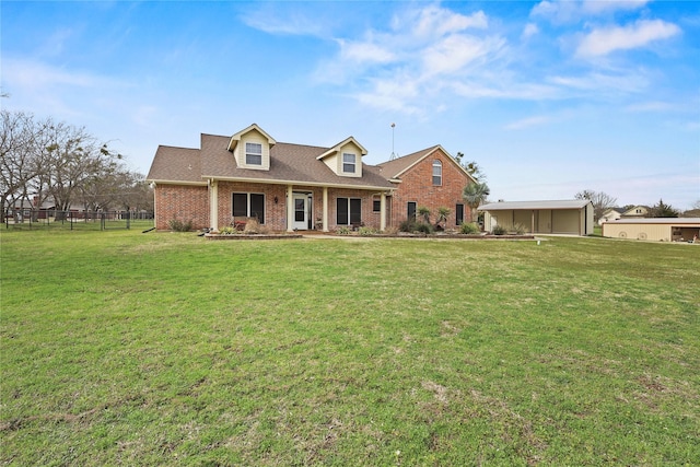 cape cod-style house with a shingled roof, brick siding, fence, and a front lawn