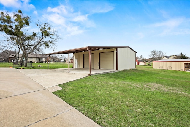 view of front of property with a garage, a front yard, an outdoor structure, and driveway