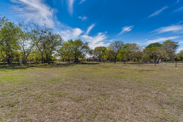 view of yard with fence and a rural view