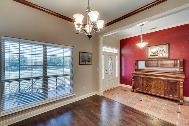 entrance foyer with hardwood / wood-style flooring, an inviting chandelier, and crown molding