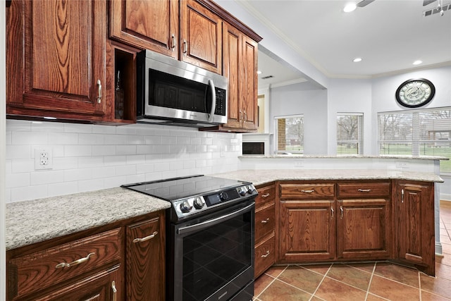 kitchen featuring stainless steel appliances, backsplash, a peninsula, and light stone counters