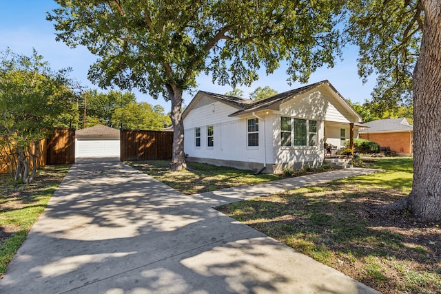 view of front of property with covered porch, a garage, and an outbuilding