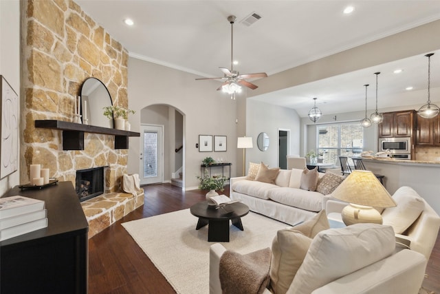 living room featuring dark hardwood / wood-style flooring, a fireplace, ornamental molding, and ceiling fan