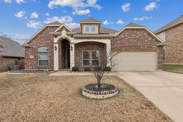 view of property featuring a garage and a front lawn