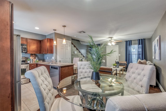 tiled dining area featuring ceiling fan and sink