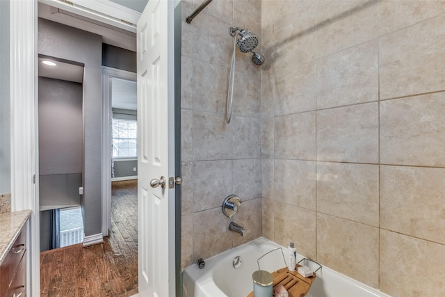 bathroom with vanity, hardwood / wood-style floors, and tiled shower / bath