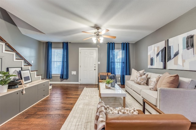 living room with ceiling fan, plenty of natural light, and dark wood-type flooring