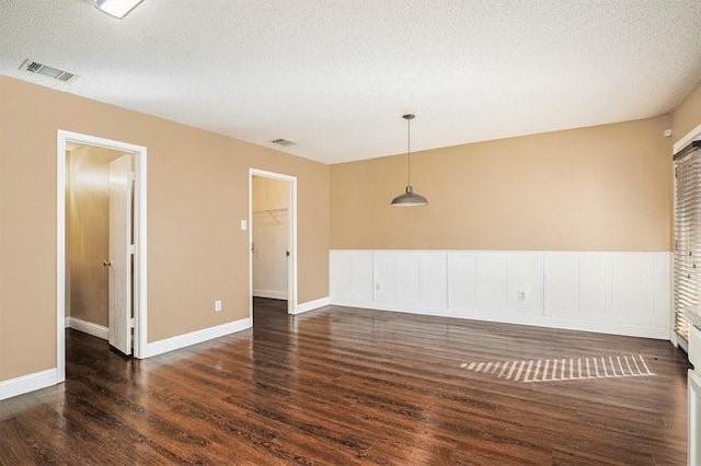 unfurnished room featuring dark hardwood / wood-style floors and a textured ceiling