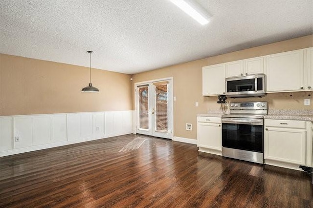 kitchen with hanging light fixtures, white cabinetry, and appliances with stainless steel finishes