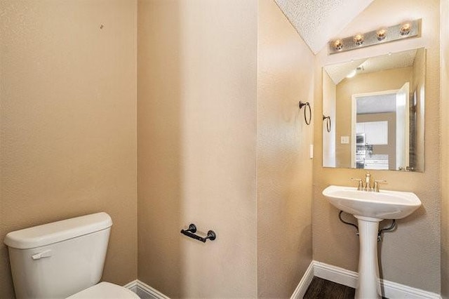 bathroom featuring lofted ceiling and toilet