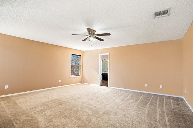 spare room featuring carpet floors, a textured ceiling, and ceiling fan