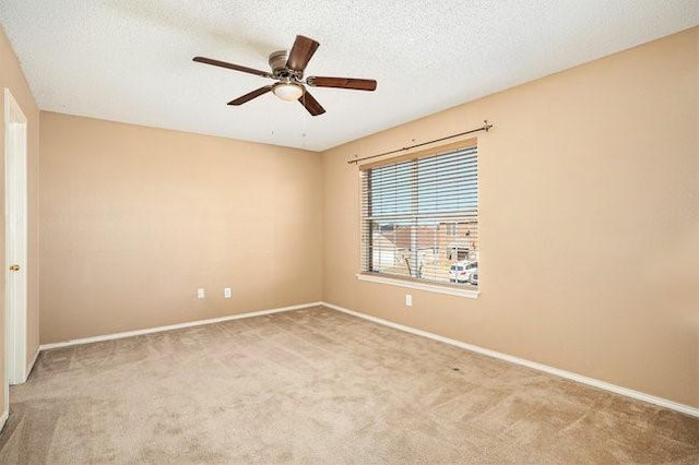 unfurnished room with ceiling fan, light carpet, and a textured ceiling